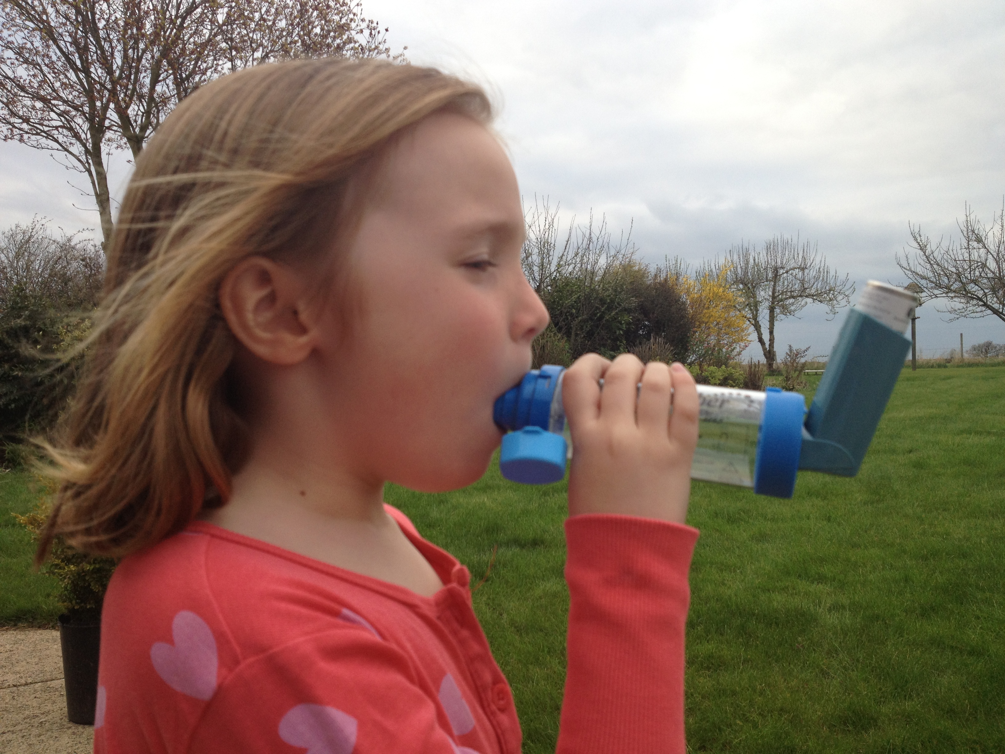 Child using inhaler for asthma